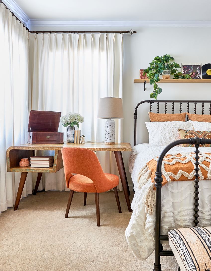 Bedroom with orange accent chair at a desk