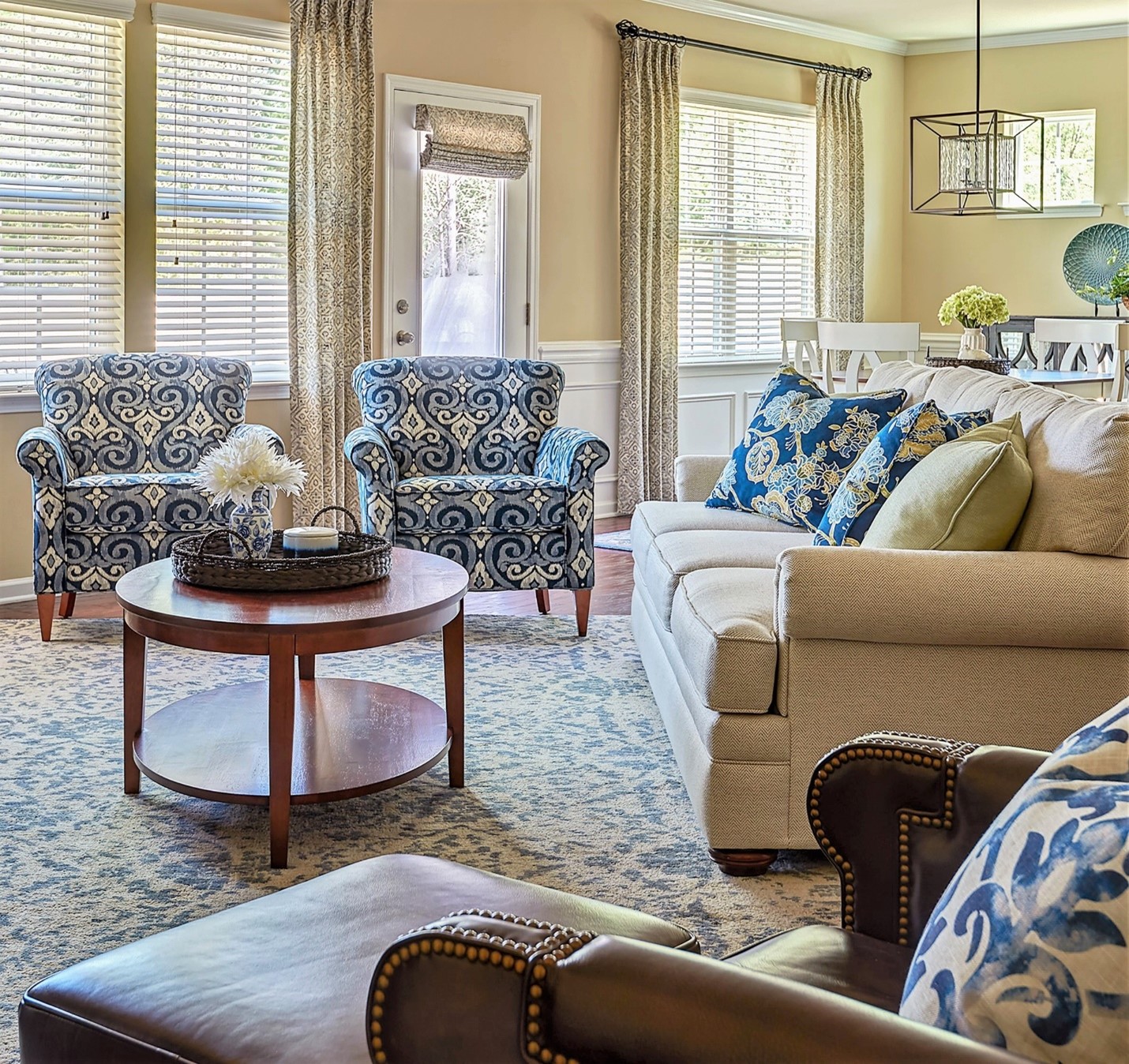 Family Room with nuetral sofa, large print blue chairs and patterned pillows