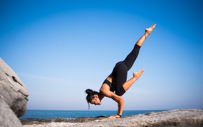 Lady doing a tough yoga balancing pose on her hands