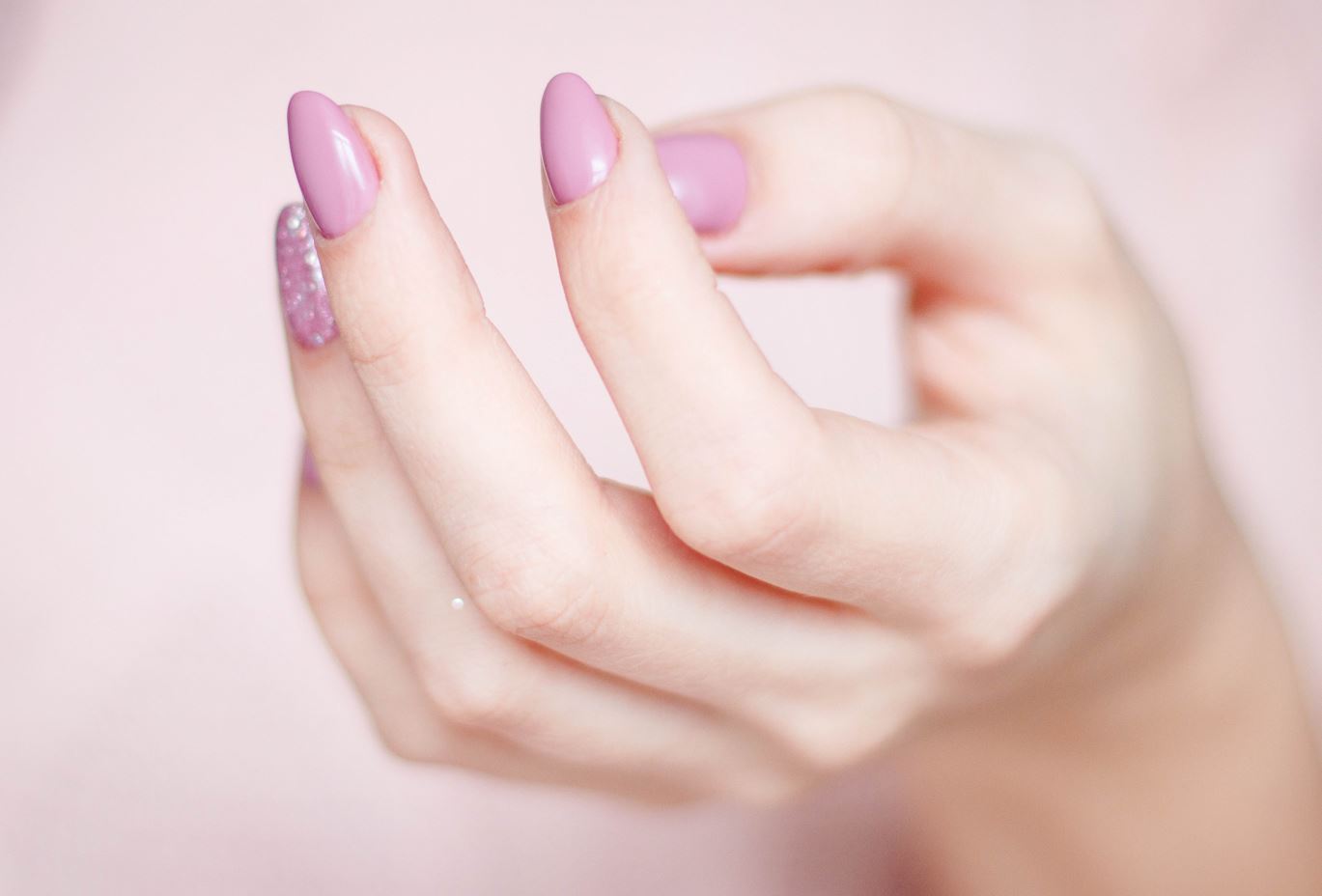 Woman's hand with light pink manicured nails